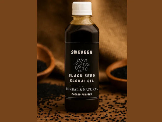 Glass bottle of dark oil with a white label on a wooden table.