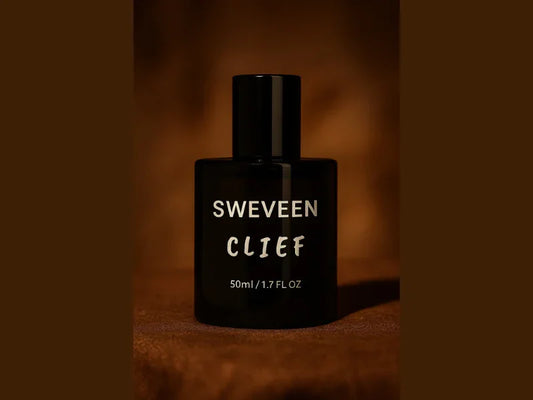 Black perfume bottle with silver lettering on a brown background.
