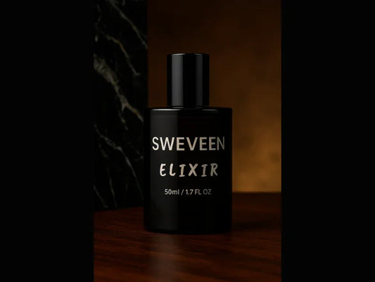 Black perfume bottle with silver lettering on a dark wooden surface.