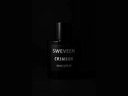 Black perfume bottle with silver text on a black background.